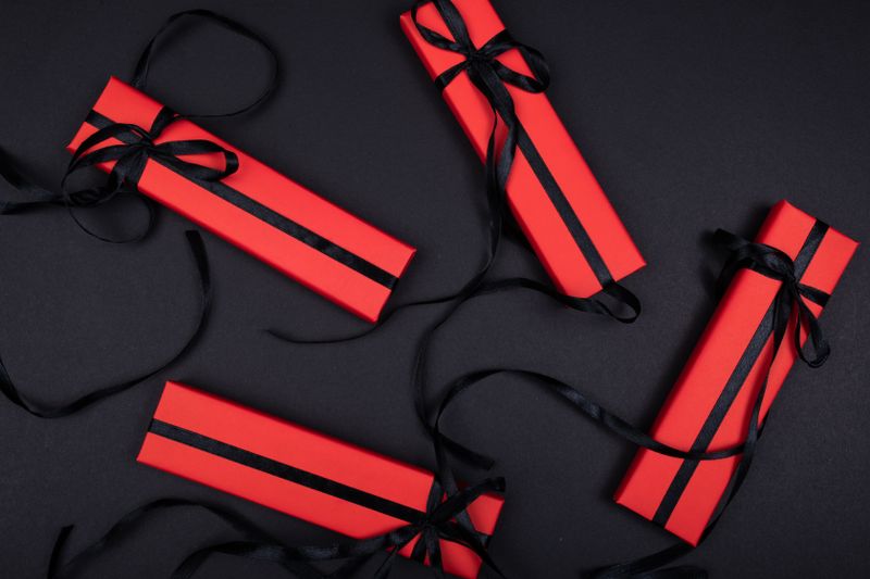 Kotak kado merah di atas latar hitam untuk program bonus referral