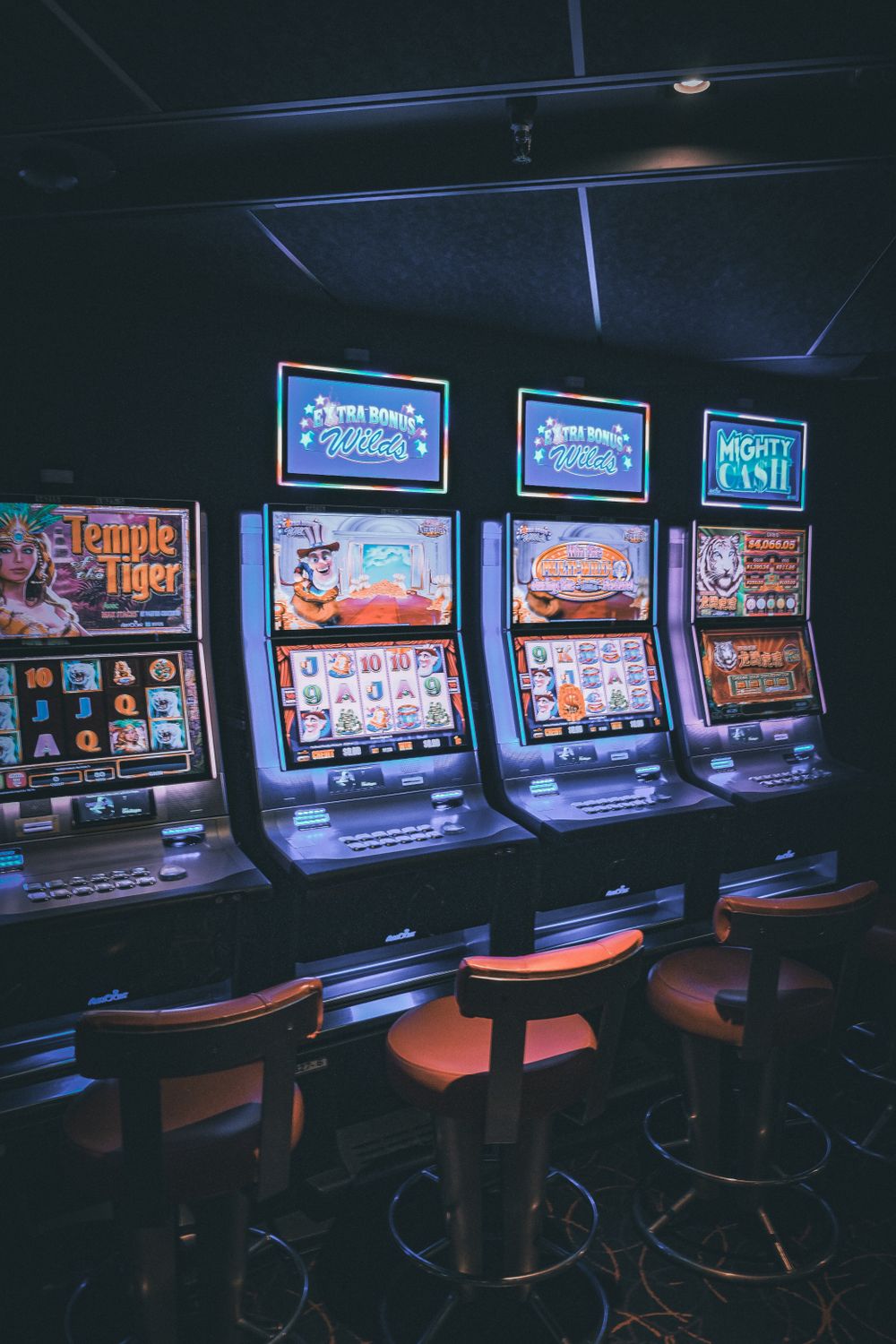 Deretan mesin slot bercahaya di lantai kasino